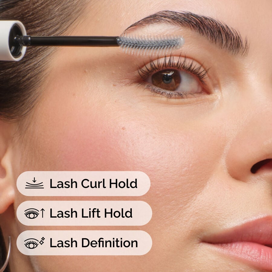Close-up of a person applying The Ordinary Lash Curl Finisher with its brush to their eyelashes. Text overlays highlight benefits: Lash Curl Hold, Lash Lift Hold, and Lash Definition, showing product efficacy.